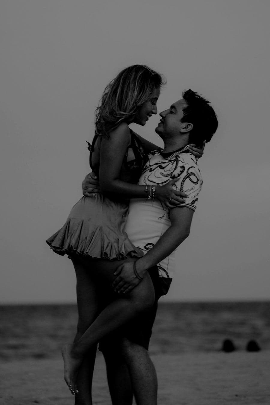 Valentina en brazos de Wysler en la playa